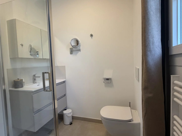 Salle de bain moderne avec douche, lavabo et toilettes dans un appartement à Cannes.