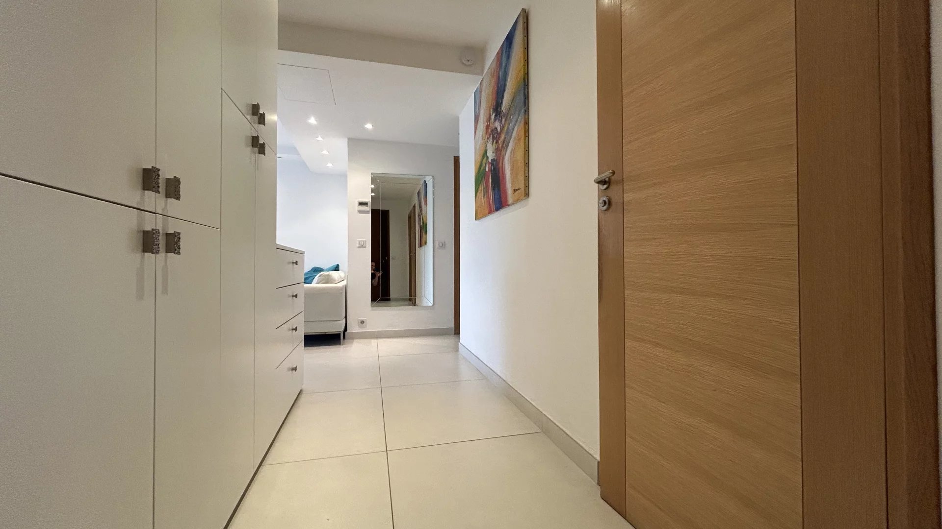Apartment entrance in Cannes Entrance to a modern apartment with light walls and tiled floor.