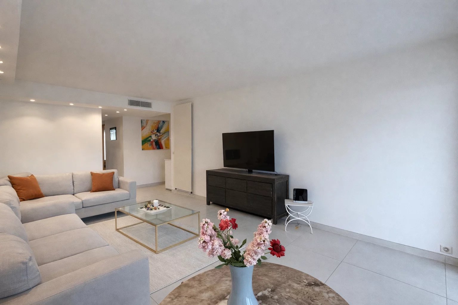 Living room of an apartment in Cannes Bright living room of a 76 m² apartment in Cannes, with sofa, television and modern decor.