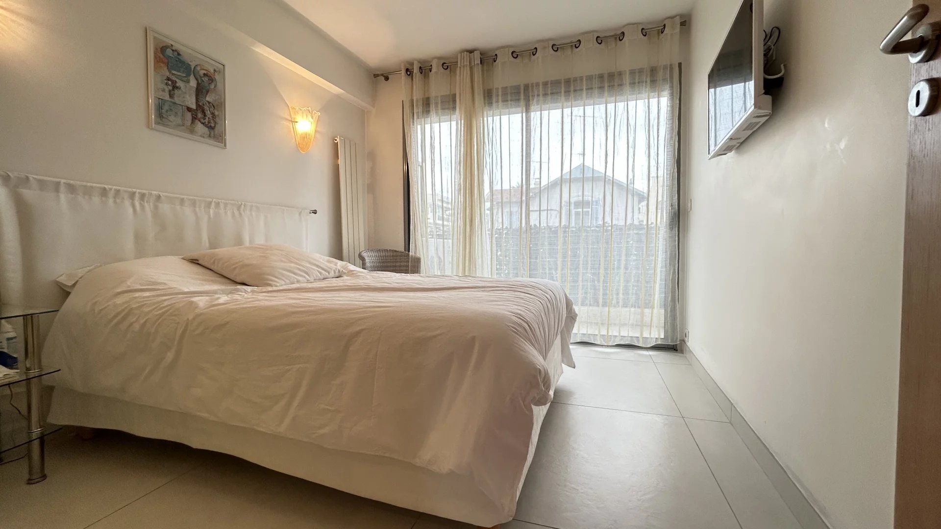 Apartment room in Cannes Room in a Cannes apartment with a double bed and a window overlooking a terrace.