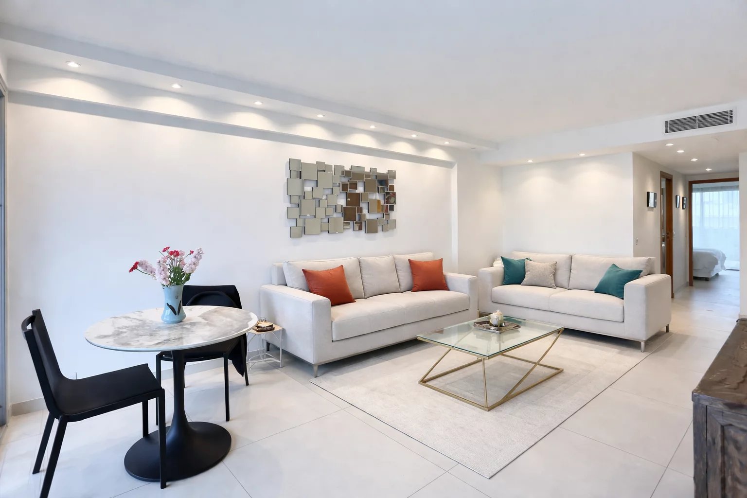 Living room of an apartment in Cannes Living room of a modern apartment with light-colored sofas, dining table and contemporary decor.