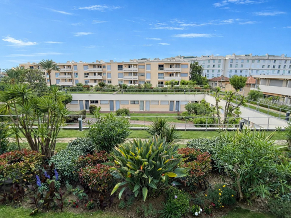 Vue de la résidence sécurisée à Cannes avec jardins et appartements en arrière-plan.