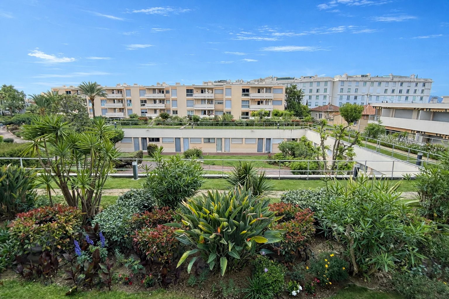 Secure residence in Cannes View of the secure residence in Cannes with gardens and apartments in the background.