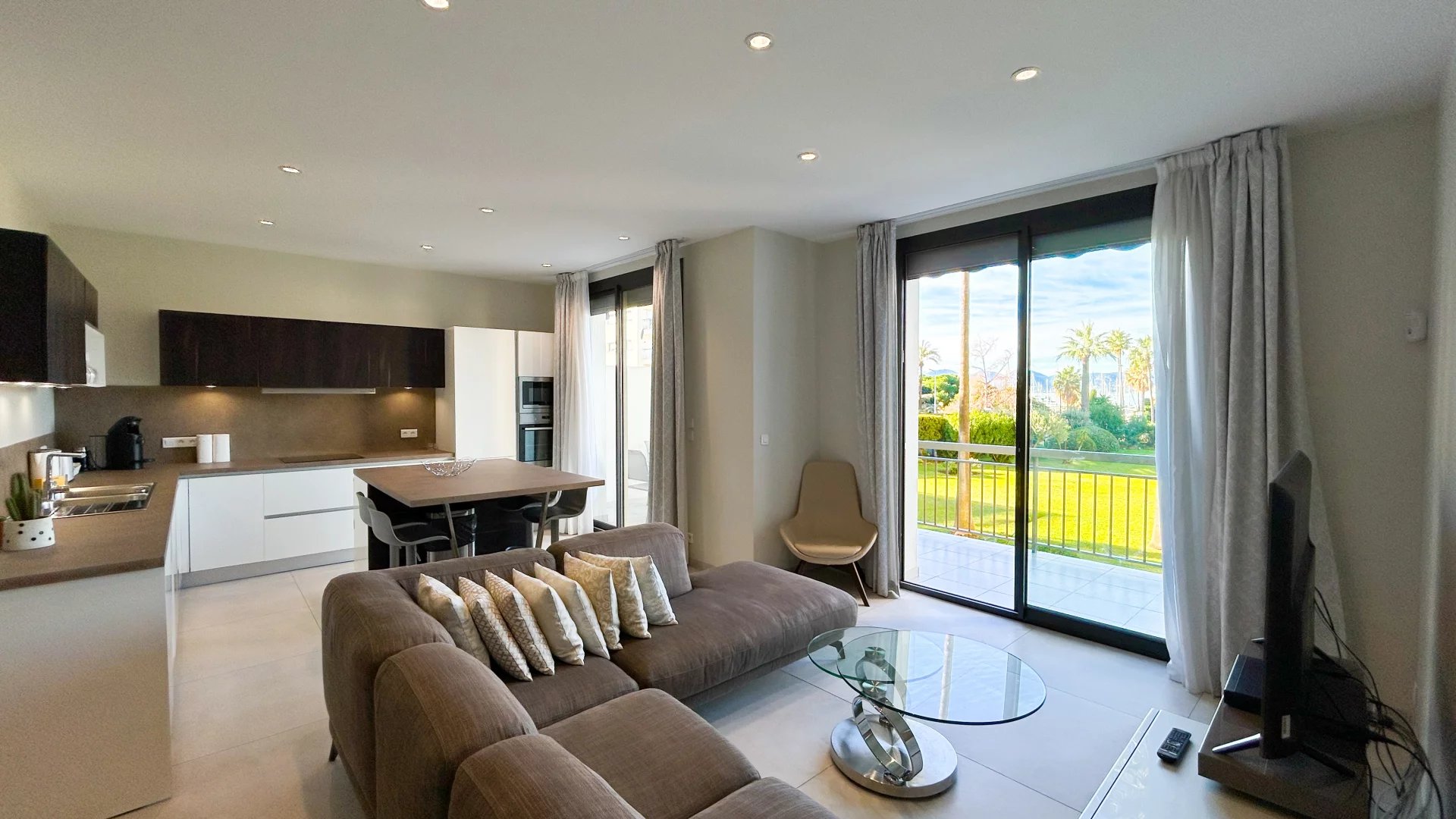 Appartement moderne à Cannes Intérieur d'un appartement moderne avec salon, cuisine ouverte et vue sur un jardin à Cannes.