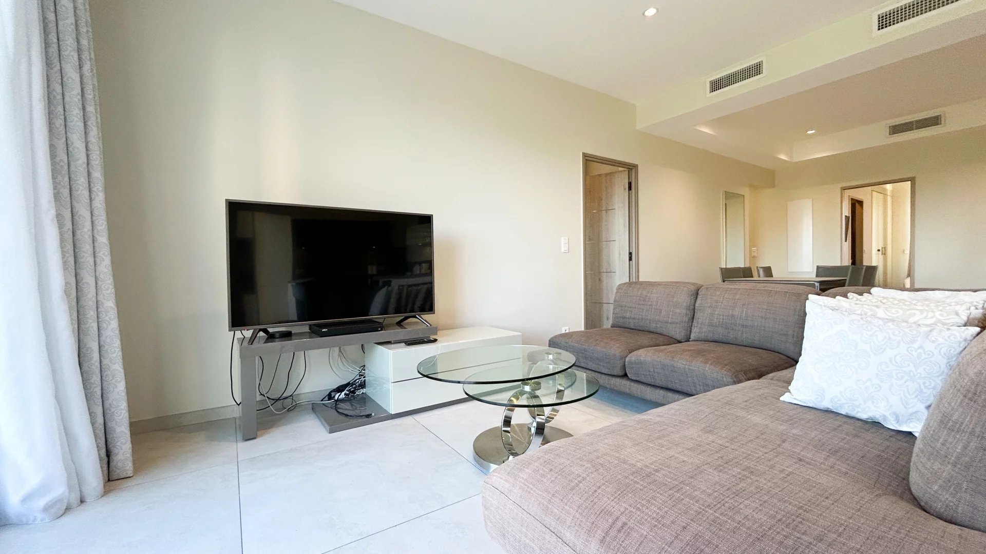 Salon d’un appartement à Cannes Salon moderne d'un appartement à Cannes avec télévision et canapé.