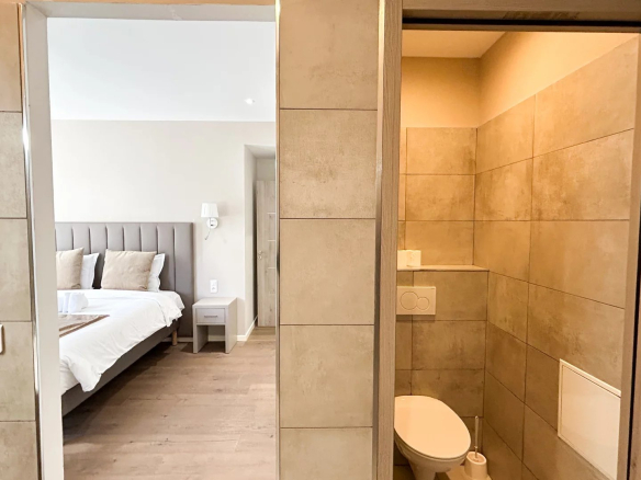Salle de bain et chambre d'un appartement rénové à Cannes, avec carrelage moderne et mobilier élégant.