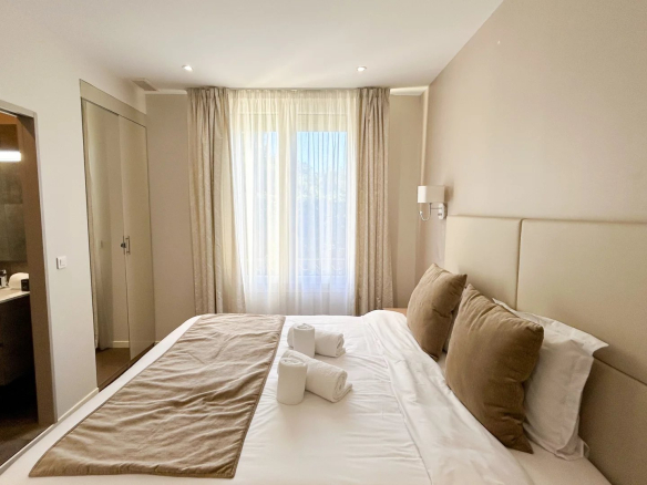 Chambre d'un appartement rénové à Cannes, avec lit double et salle de bain attenante.