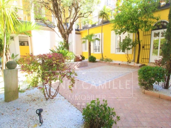 Terrasse/jardin calme d'un appartement à Cannes, avec plantes et pavés.