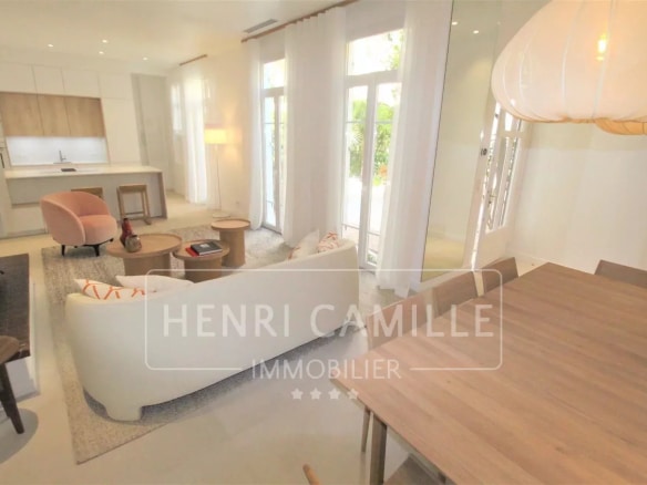Intérieur d'un appartement rénové à Cannes avec salon et salle à manger lumineuse.