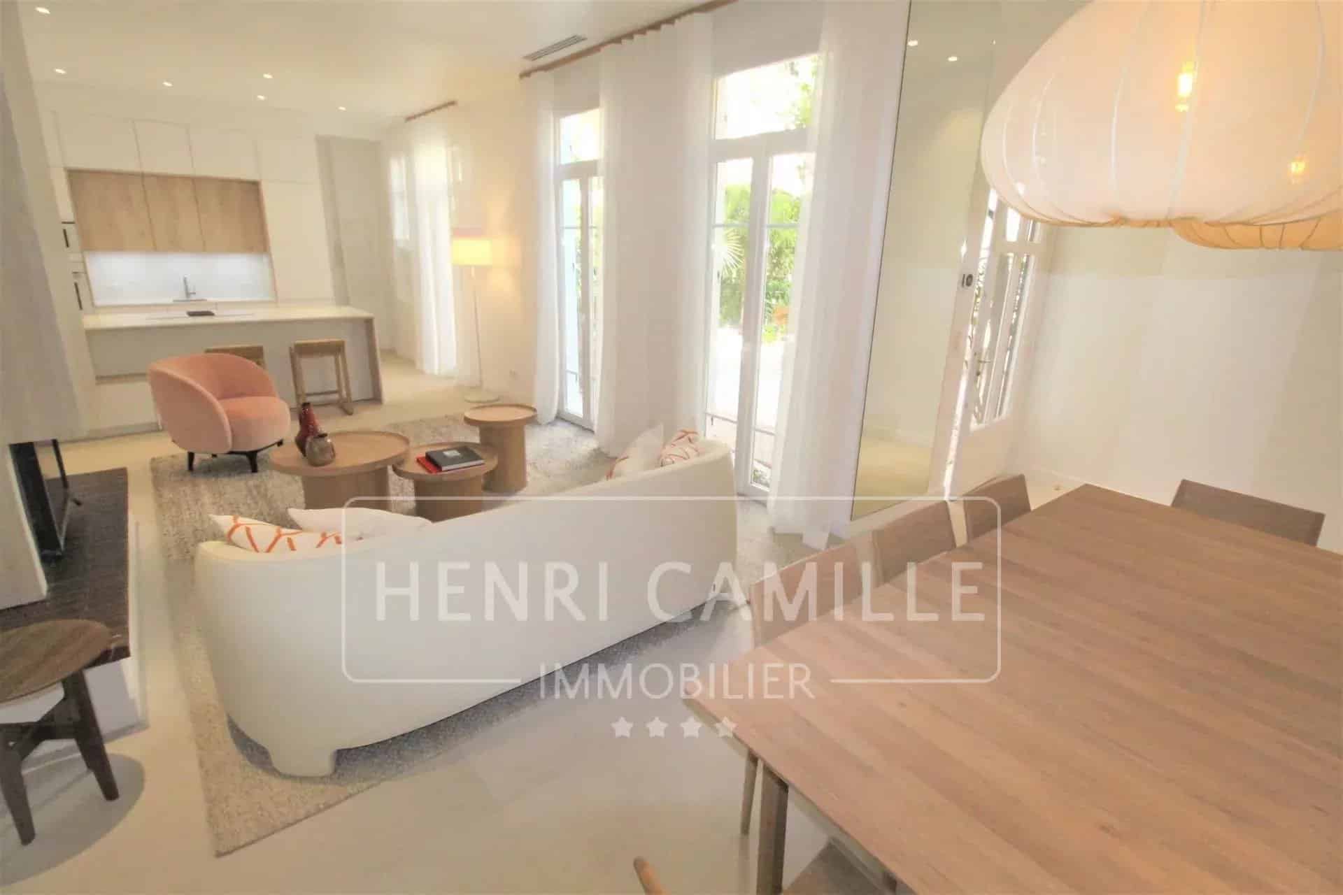 Intérieur d'un appartement rénové à Cannes avec salon et salle à manger lumineuse.