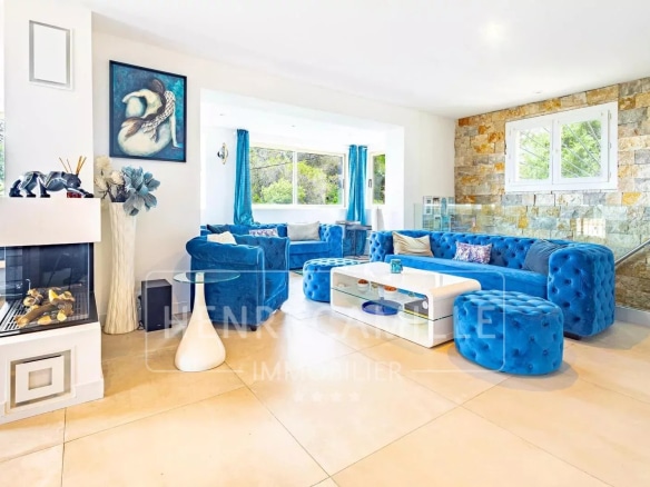 Intérieur d'une villa contemporaine avec un salon spacieux et des meubles bleus.