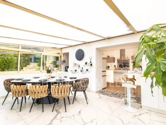 Intérieur d'une villa contemporaine avec salle à manger et cuisine ouverte, décor moderne.