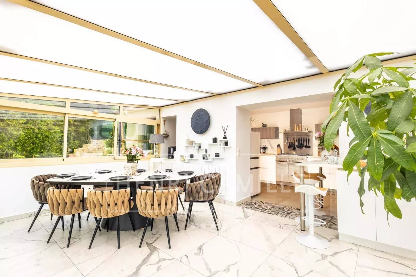 Intérieur d'une villa contemporaine avec salle à manger et cuisine ouverte, décor moderne.