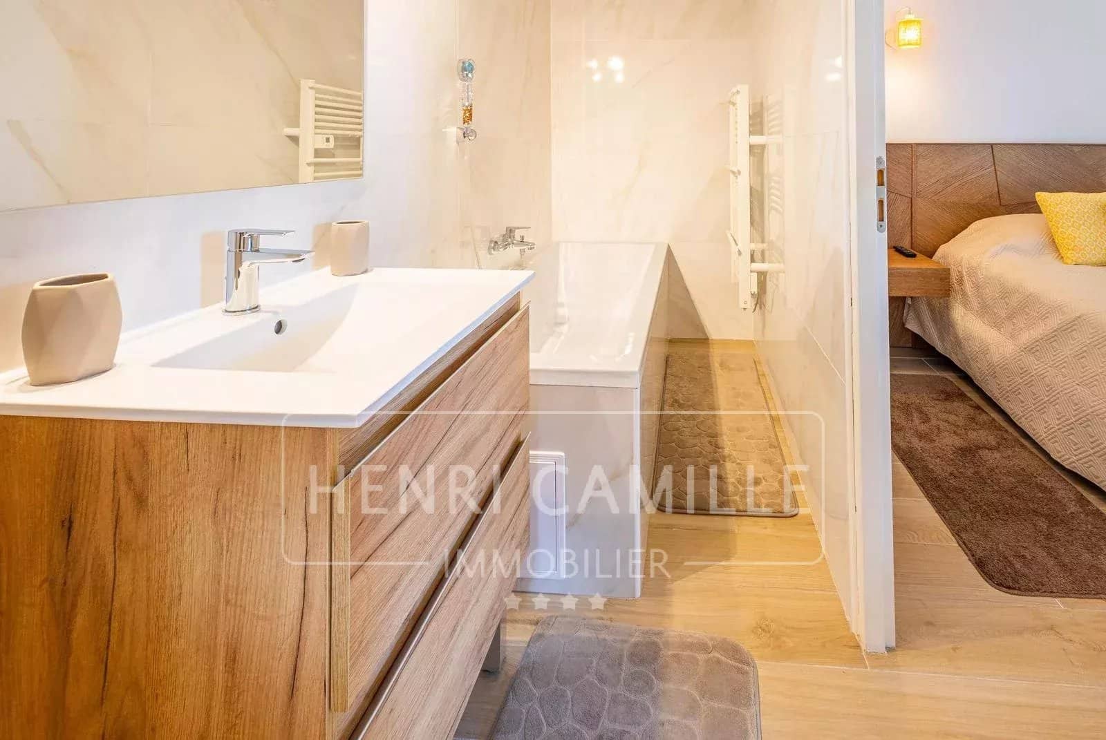 Salle de bain moderne avec baignoire et meuble en bois.