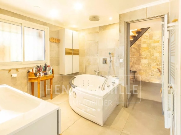 Salle de bain moderne avec baignoire et douche, éclairage naturel.