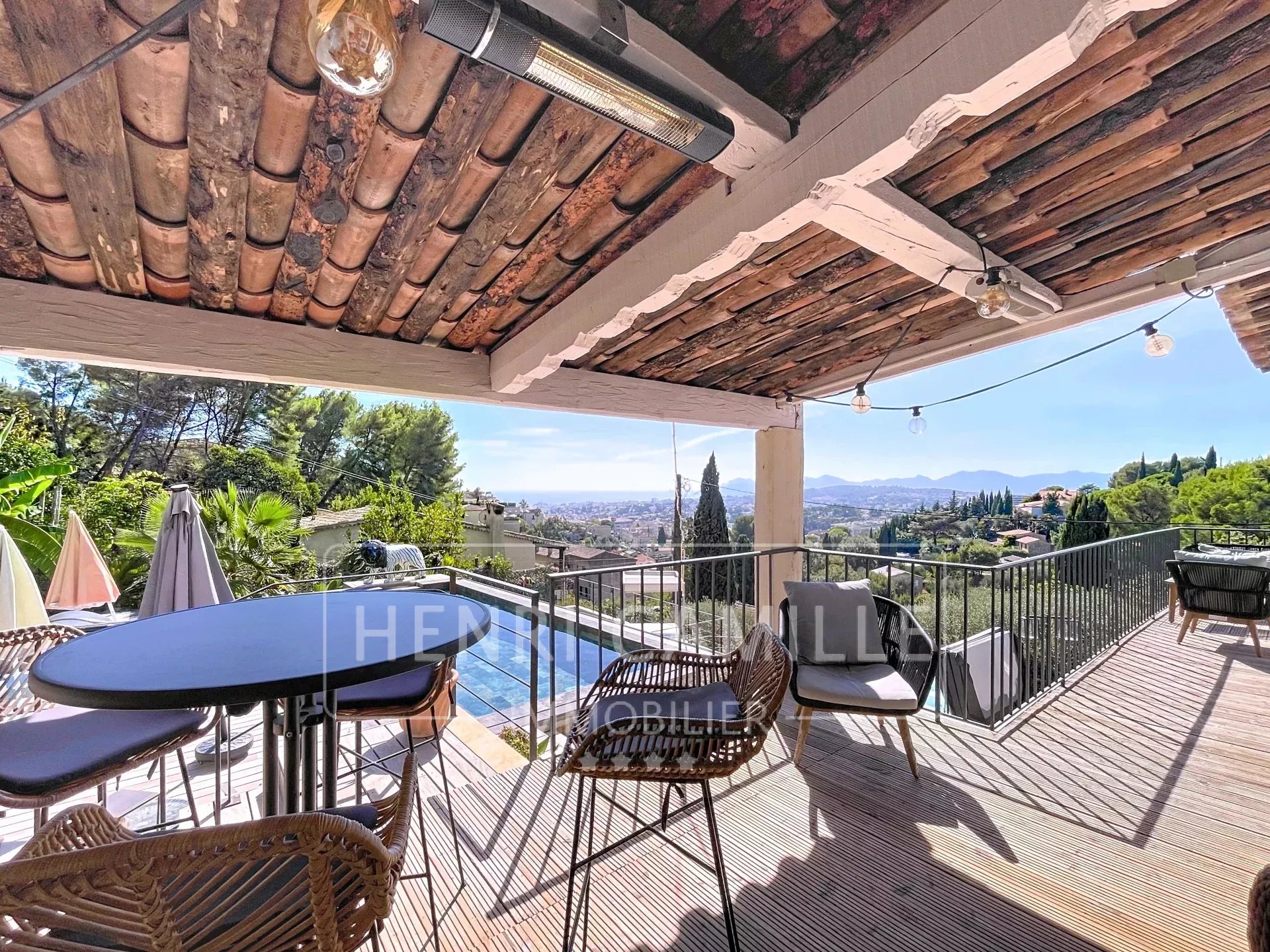Terrasse d'une villa contemporaine avec vue sur la mer et les montagnes, mobilier extérieur