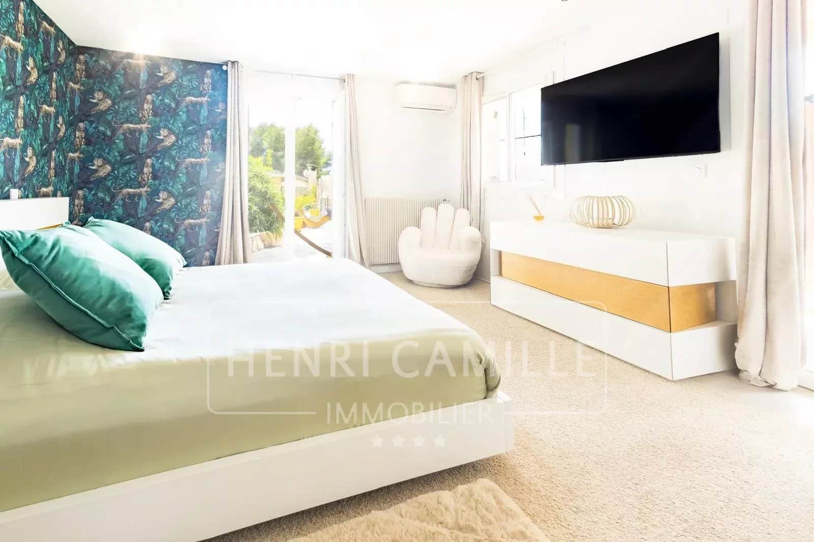 Chambre moderne avec lit double, décoration contemporaine et télévision, vue sur jardin.