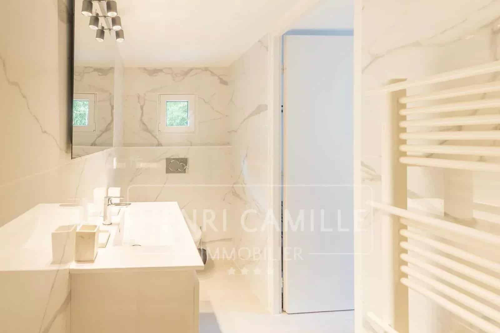 Salle de bain moderne avec carrelage en marbre et lavabo double.