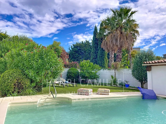 Vue d'une piscine chauffée entourée de verdure dans une villa à Cannes.