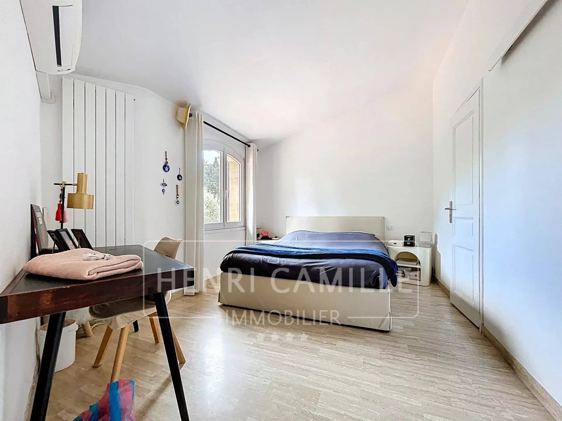 Chambre spacieuse avec lit double et bureau, lumière naturelle à Cannes.