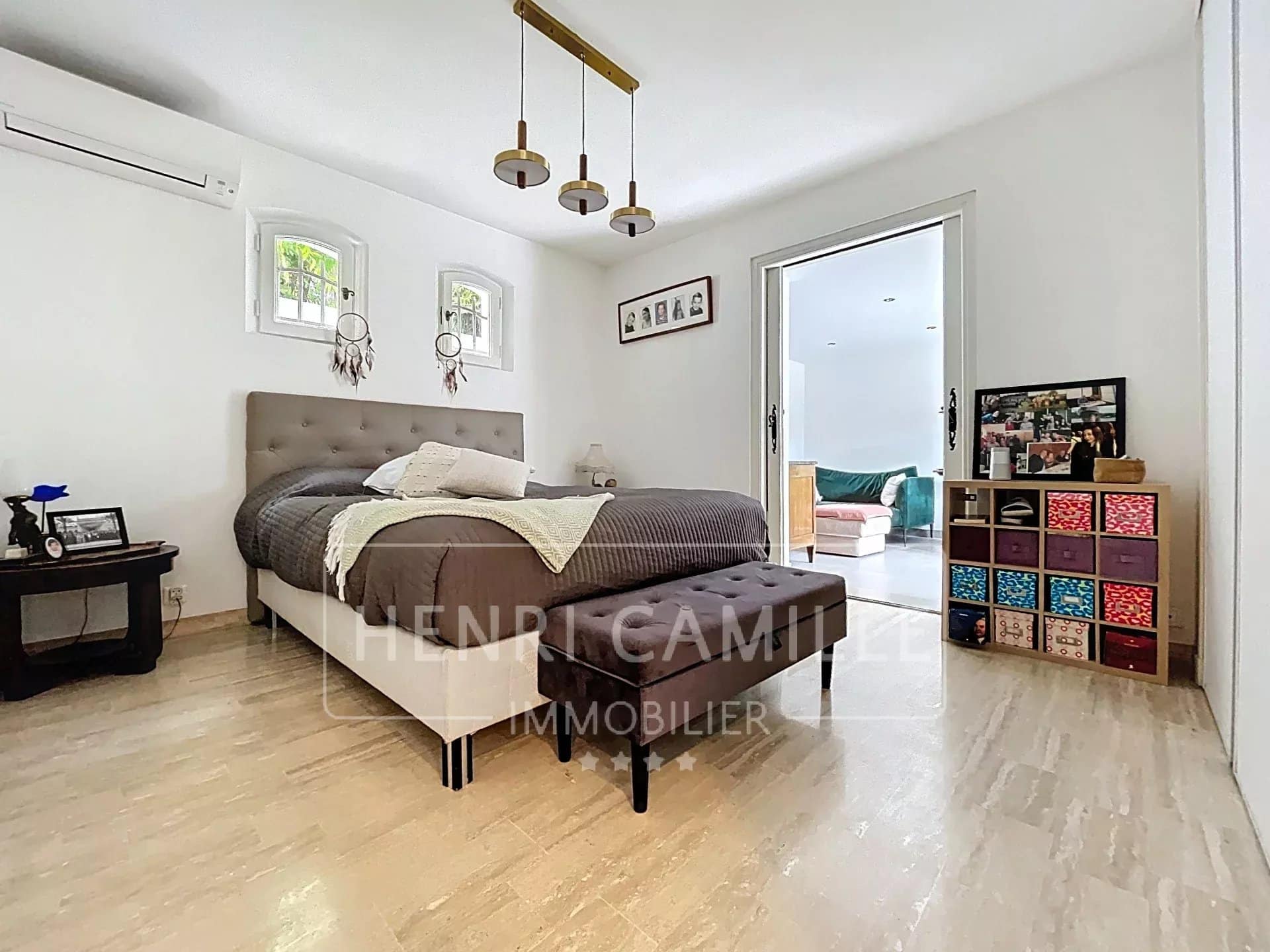 Chambre d'une villa à Cannes avec lit, banquette et accès à un salon.