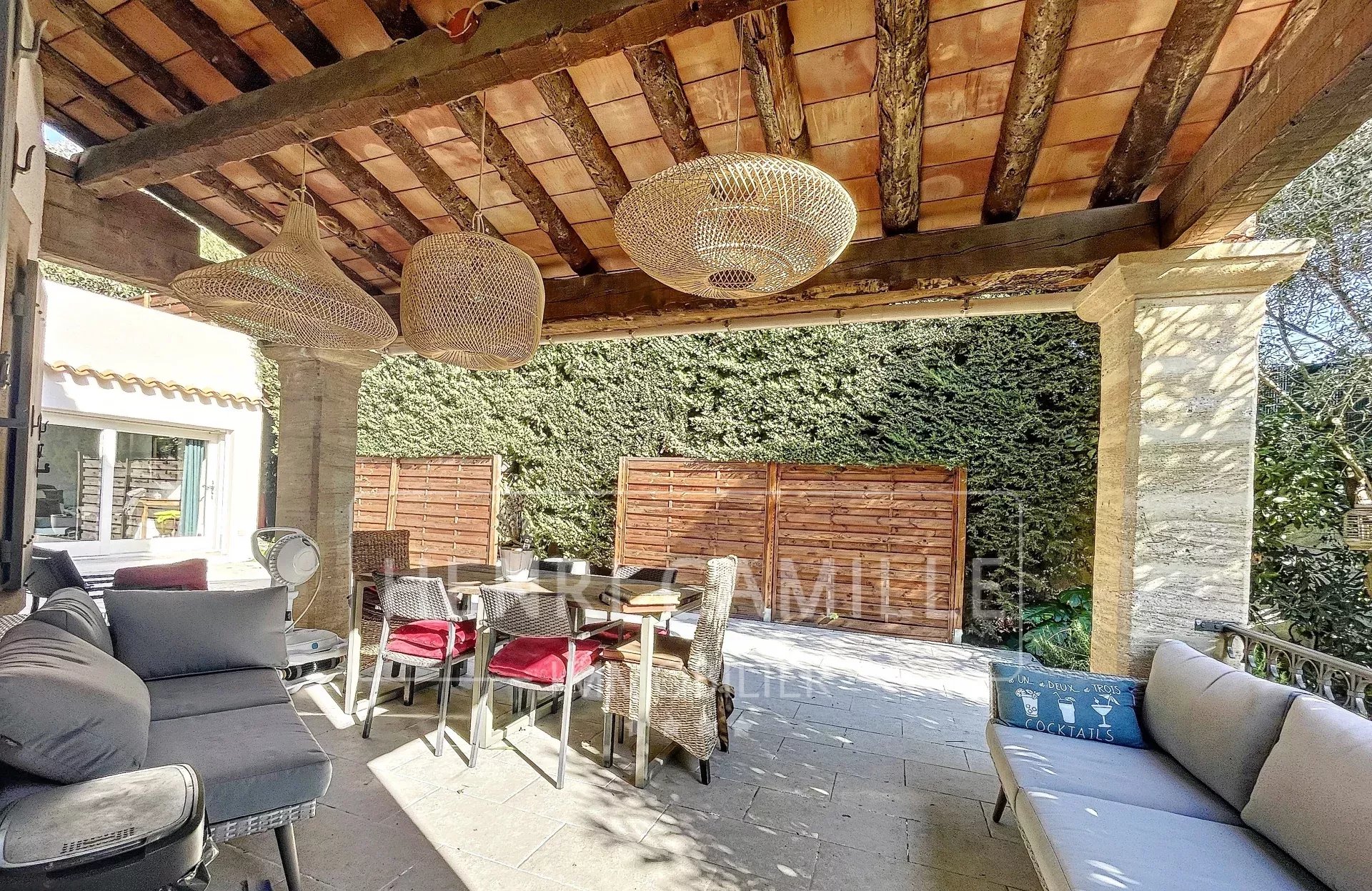 Terrasse d'une villa à Cannes avec mobilier extérieur et décoration en osier.