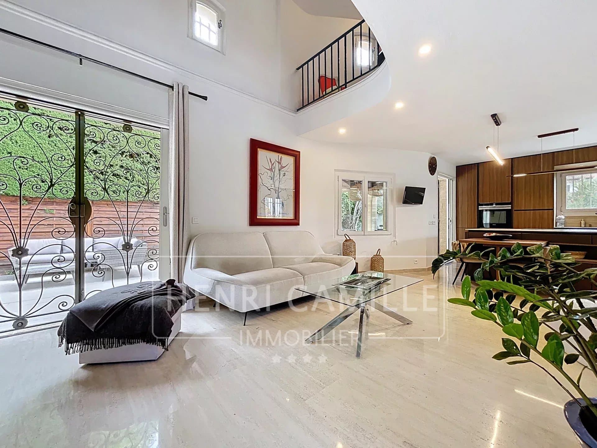 Intérieur d'une villa à Cannes avec un salon lumineux et une cuisine moderne.