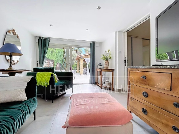 Intérieur d'une villa à Cannes avec salon lumineux et accès au jardin.