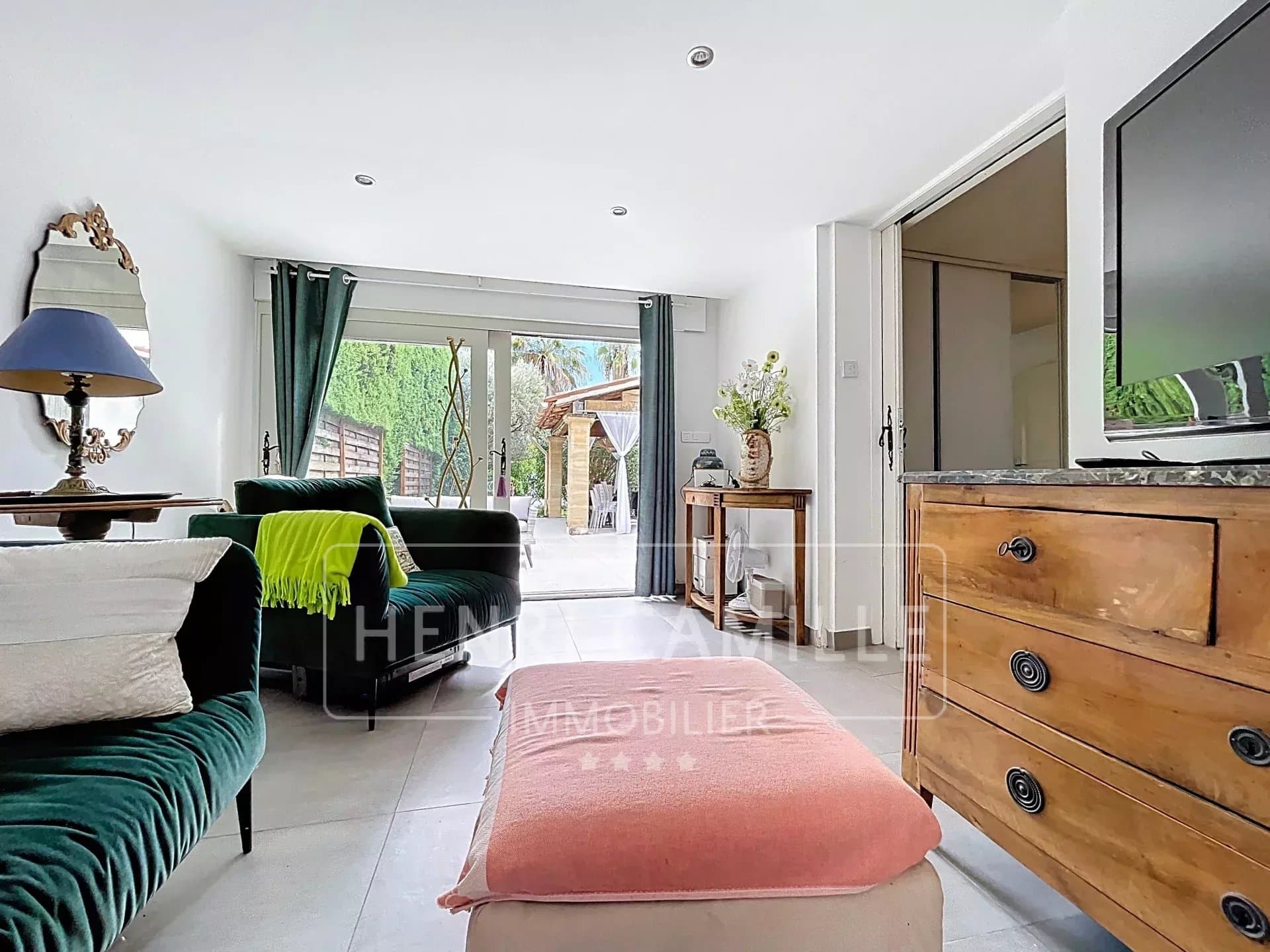 Intérieur d'une villa à Cannes avec salon lumineux et accès au jardin.