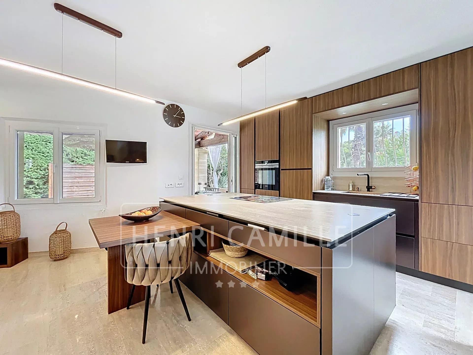 Cuisine moderne avec îlot central et coin repas dans une villa à Cannes.