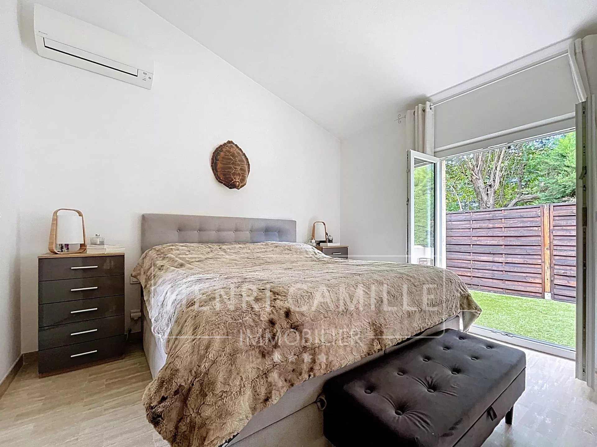 Chambre d'une villa à Cannes avec lit double et accès à un jardin.