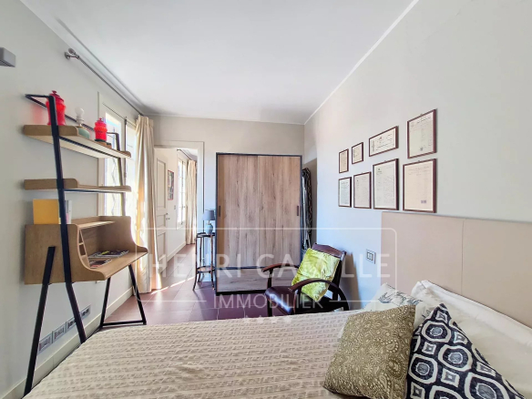 Bedroom in a Cannes apartment with modern decor and desk.