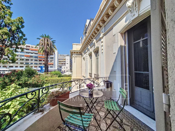 Balcony of an apartment in Cannes with views of the greenery and surrounding buildings.
