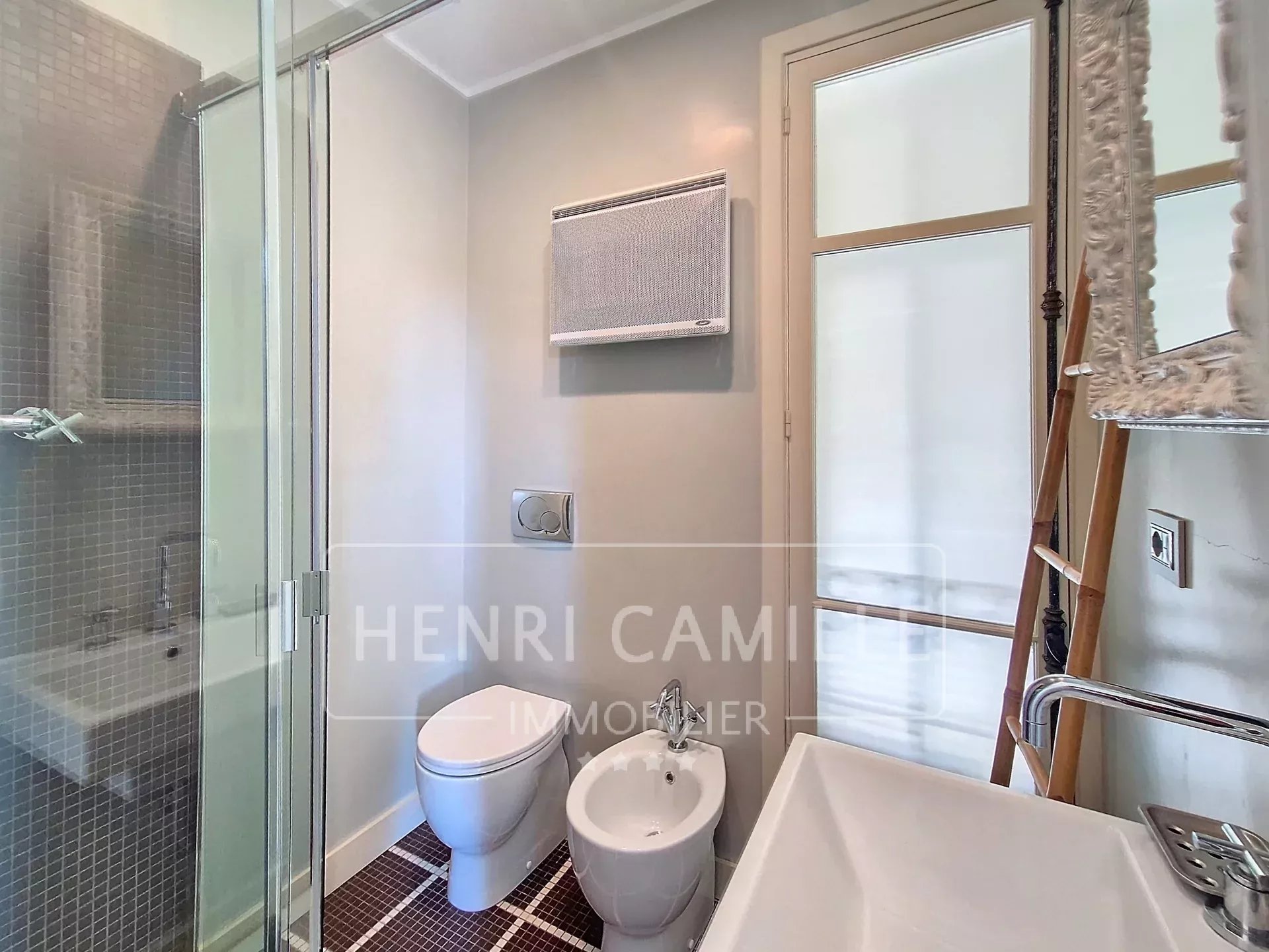 Modern bathroom with shower, toilet and sink in an apartment in Cannes.