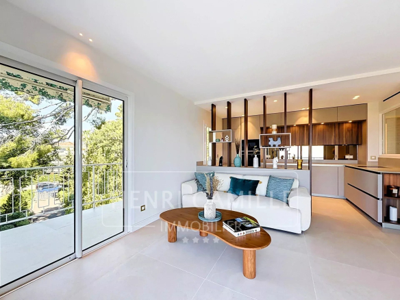 Intérieur d'un appartement rénové avec salon, cuisine équipée et accès à une terrasse.