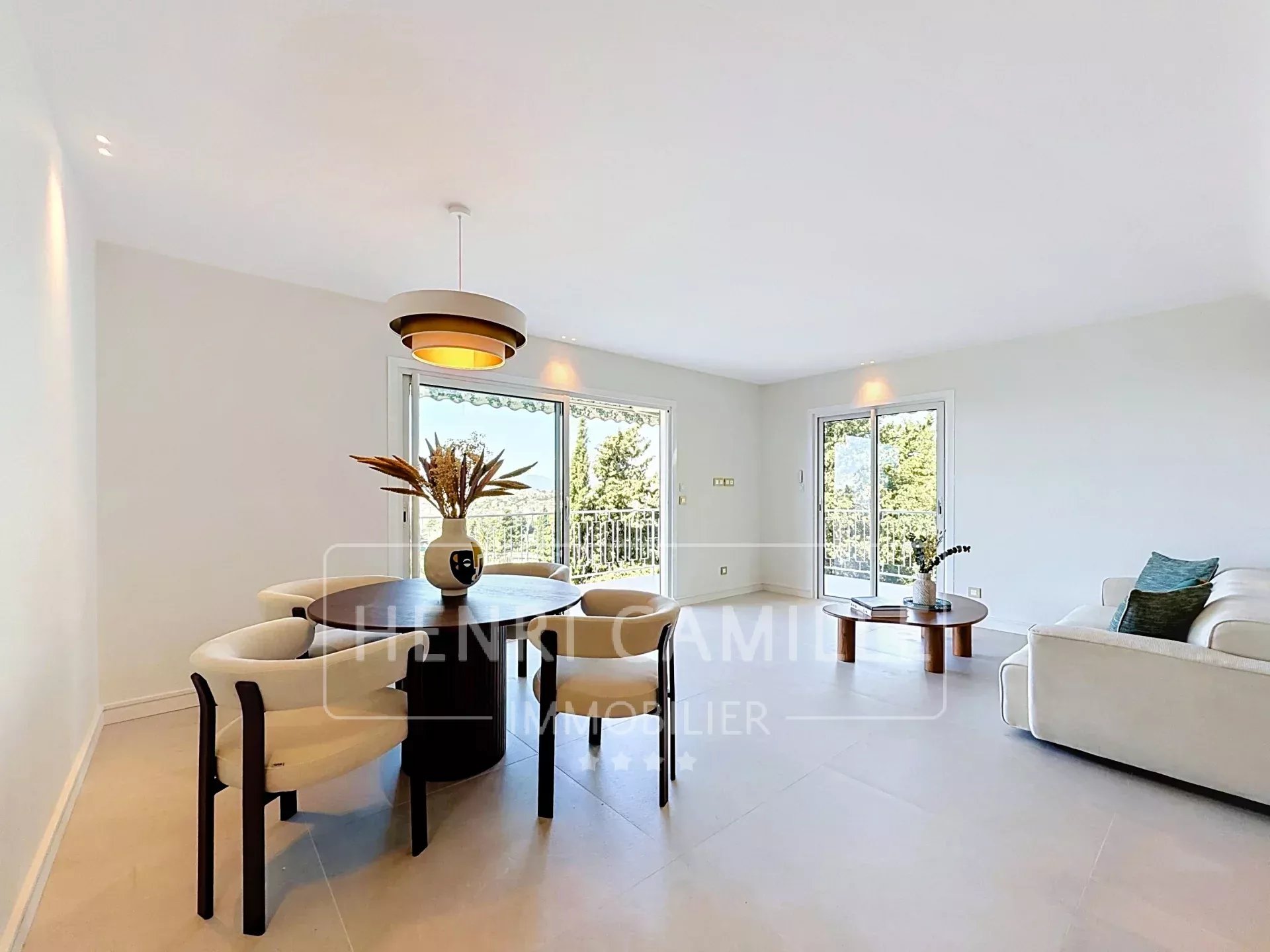 Appartement rénové à Cannes Intérieur d'un appartement rénové à Cannes avec salon, salle à manger et accès à une terrasse.