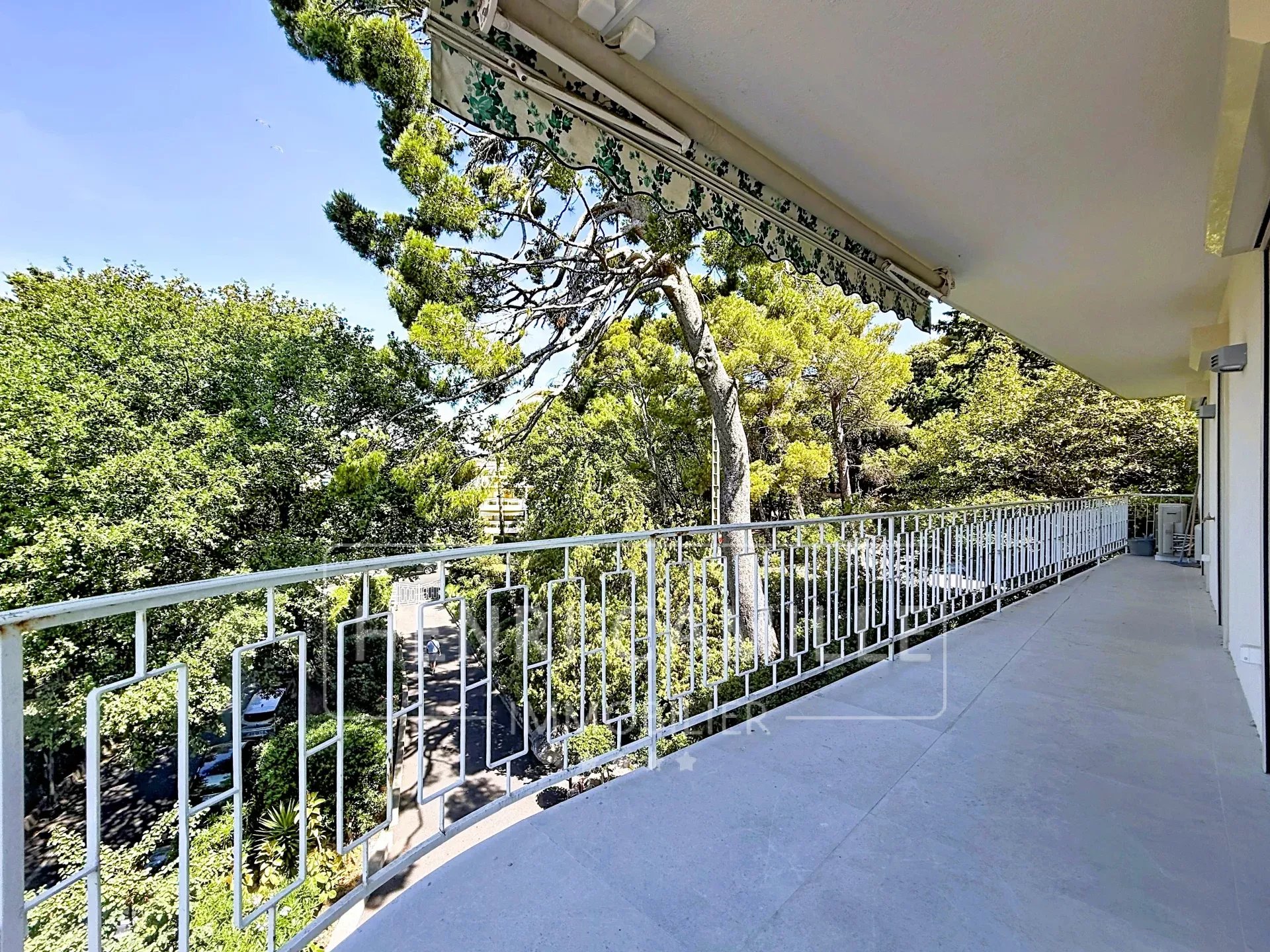 Vue panoramique depuis une terrasse à Cannes Vue panoramique depuis une terrasse d'un appartement à Cannes, entourée d'arbres.