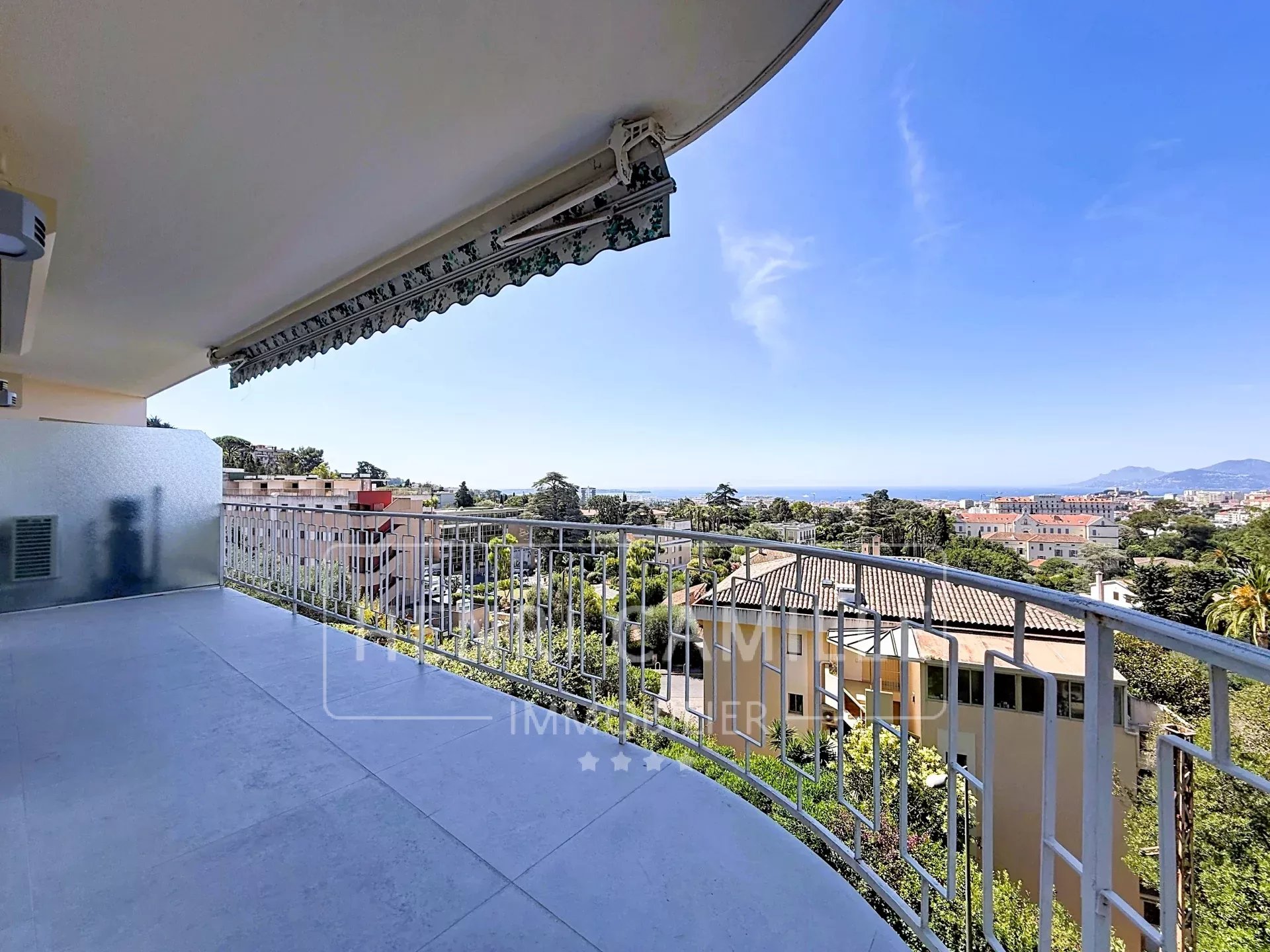 Vue panoramique sur la mer à Cannes Vue panoramique de la mer depuis une terrasse à Cannes, avec balustrade et ciel dégagé.