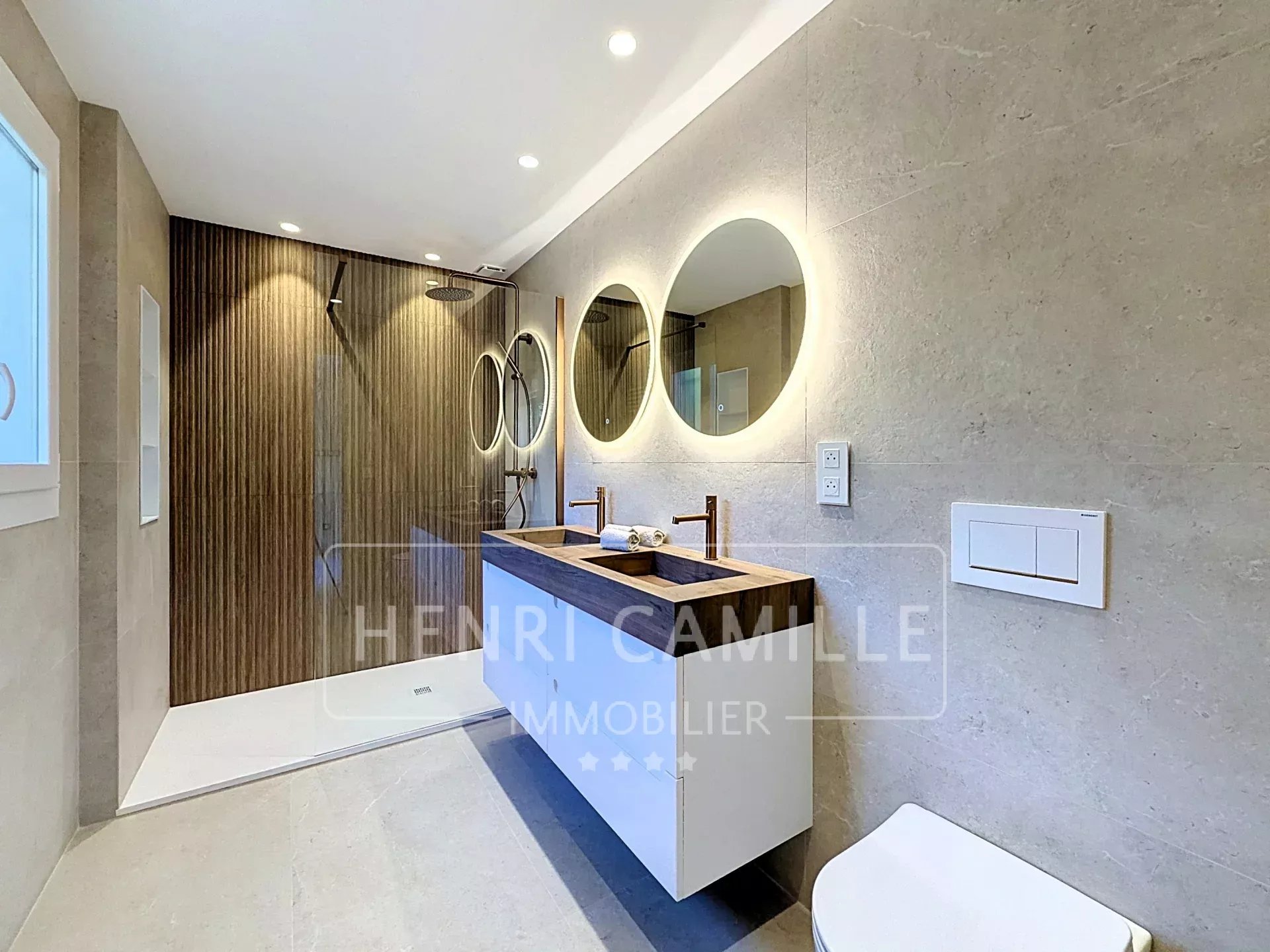 Salle de bain rénovée à Cannes Salle de bain moderne avec douche à l'italienne et double vasque.