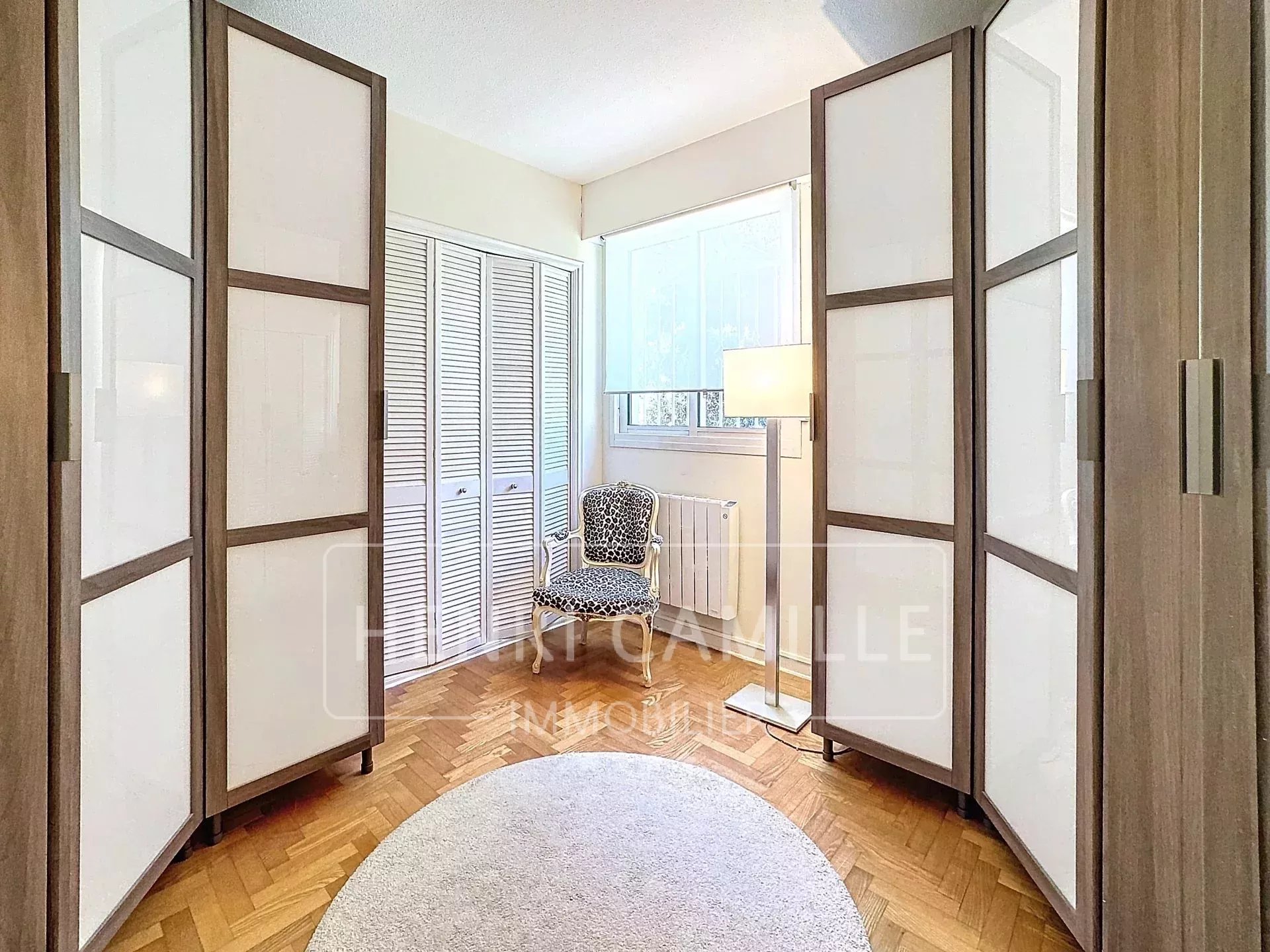 Intérieur d’un appartement au Cannet Intérieur d'un appartement avec parois en bois, fauteuil et lumière naturelle.
