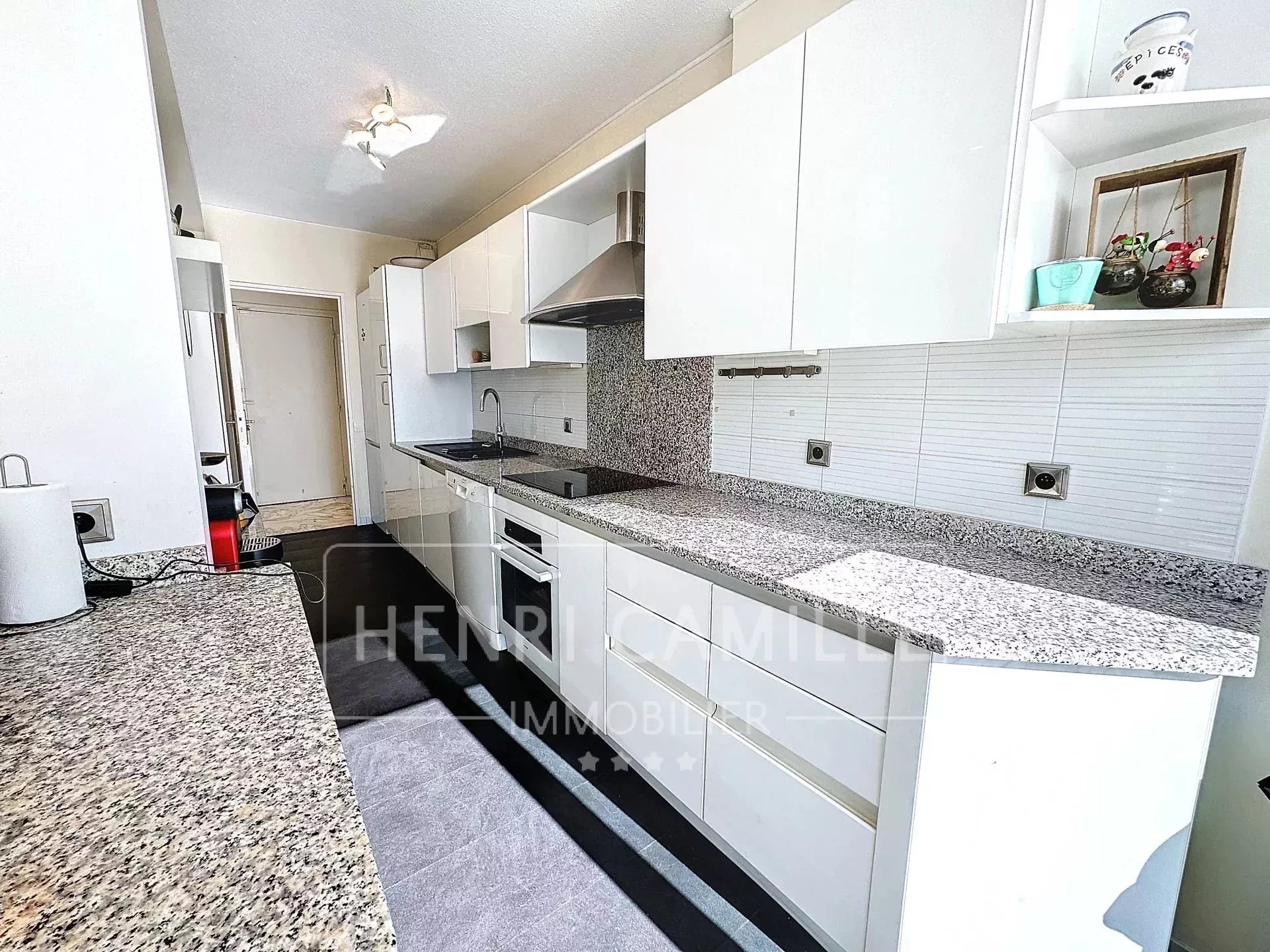 Cuisine d’un appartement au Cannet Cuisine moderne avec plans de travail en granit et équipements intégrés dans un appartement au Cannet.