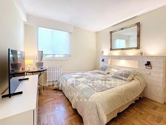 Chambre d'un appartement avec lit double, télévision et décoration sobre au Cannet.
