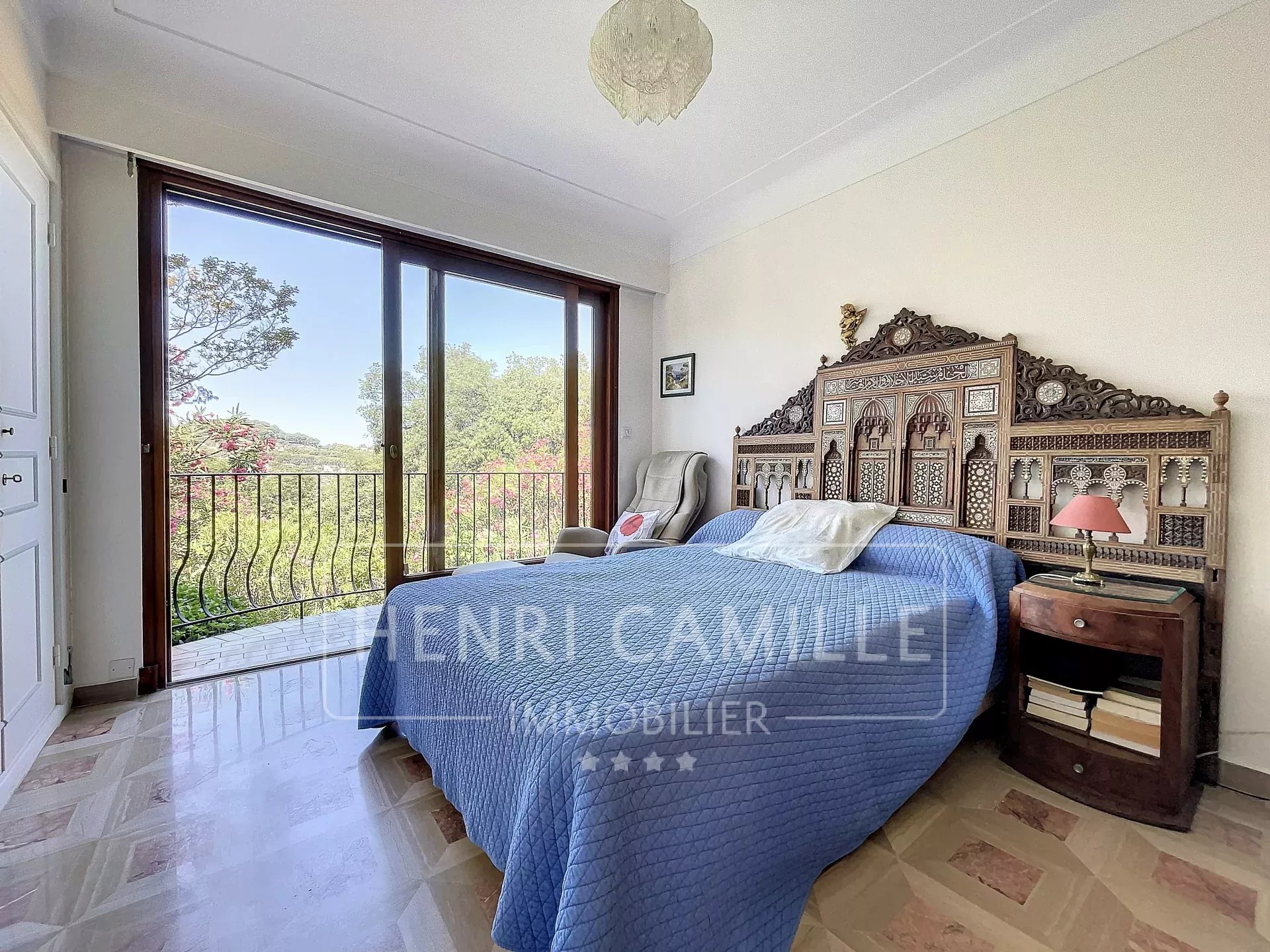 Chambre avec lit double et vue sur un jardin à Cannes, France.