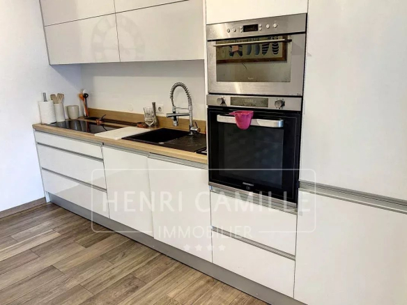Cuisine moderne d'une maison de ville à Cannes, avec meubles blancs et équipements intégrés.