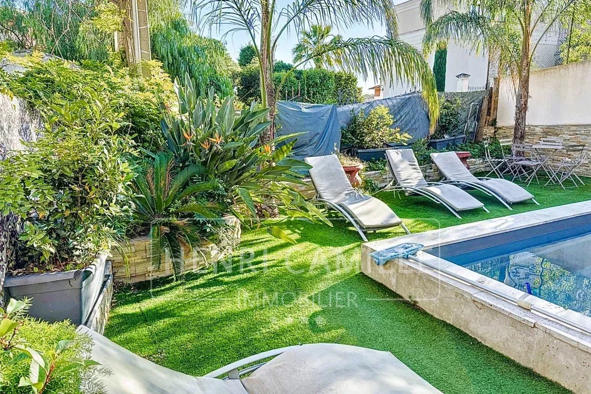 Maison avec piscine à Cannes Jardin avec piscine et chaises longues dans une maison à Cannes.