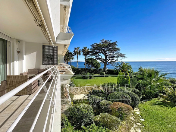 Vue depuis un appartement à Cannes avec jardin et mer en arrière-plan.