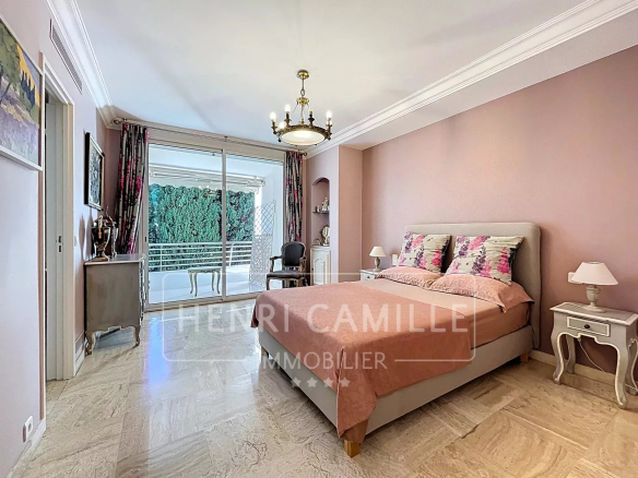 Chambre d'un appartement à Cannes avec vue sur la mer, décorée avec des teintes douces.