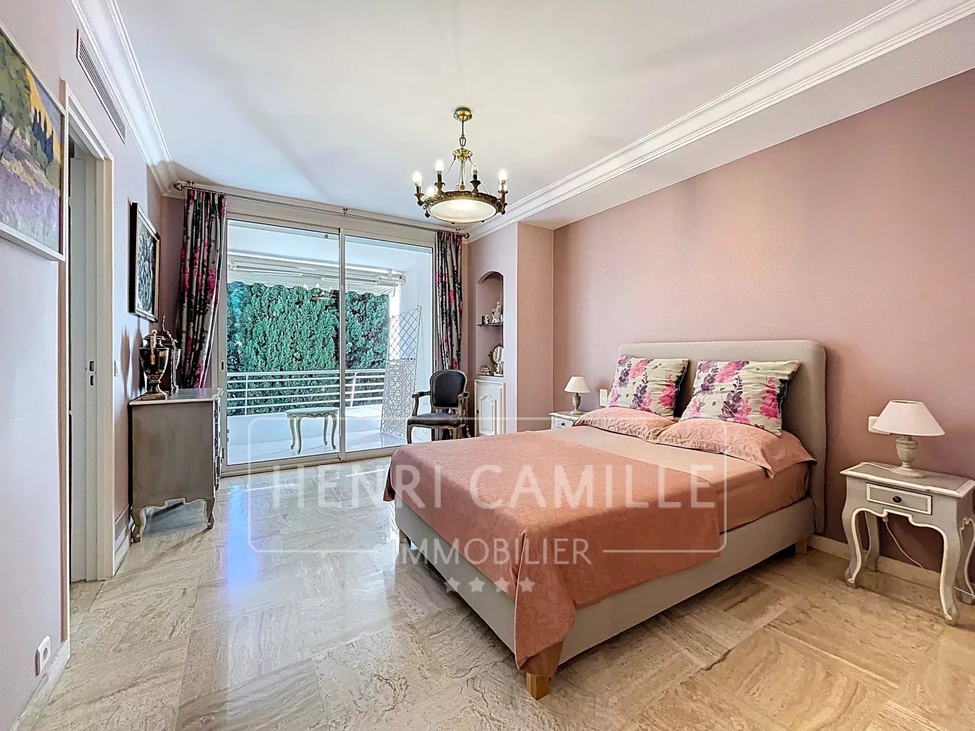Chambre d'un appartement à Cannes avec vue sur la mer, décorée avec des teintes douces.