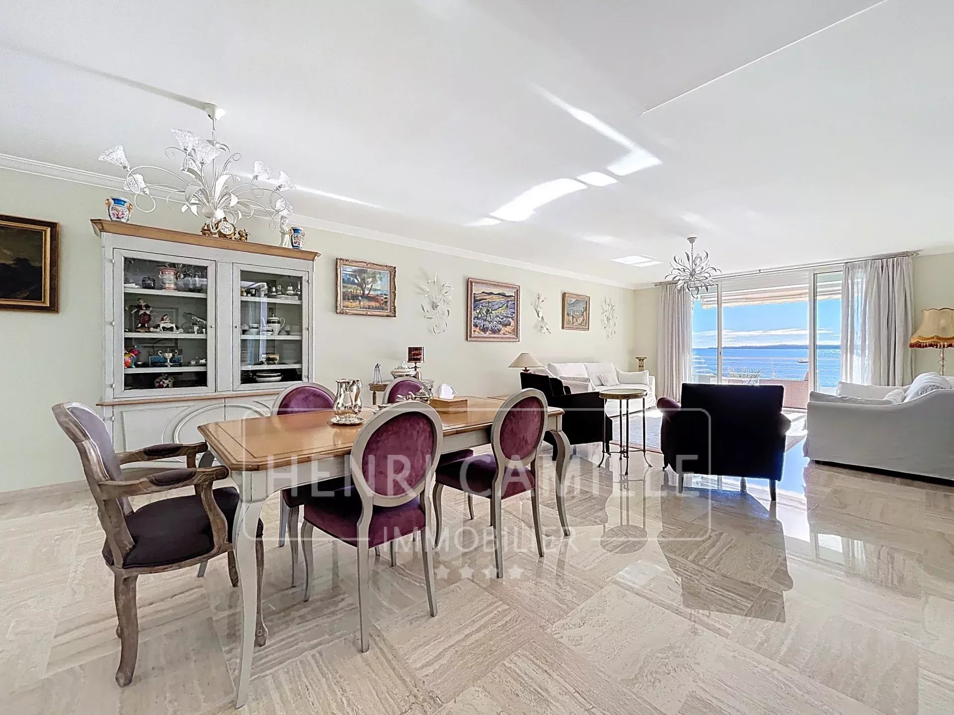 Intérieur d'un appartement spacieux avec vue sur la mer à Cannes, salle à manger et salon lumineux.