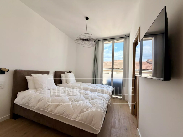 Chambre d'un appartement rénové à Cannes avec lit double et fenêtre